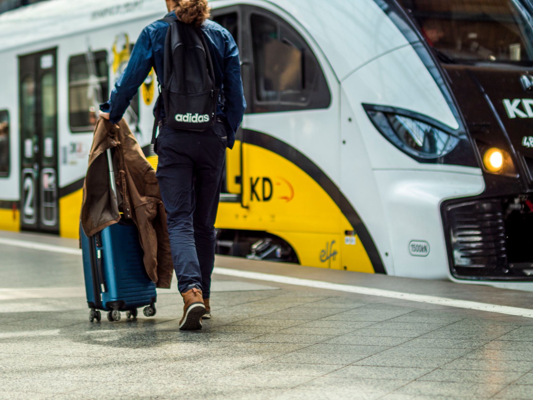 Viaggiatori con valigie in attesa nell'atrio di una stazione ferroviaria