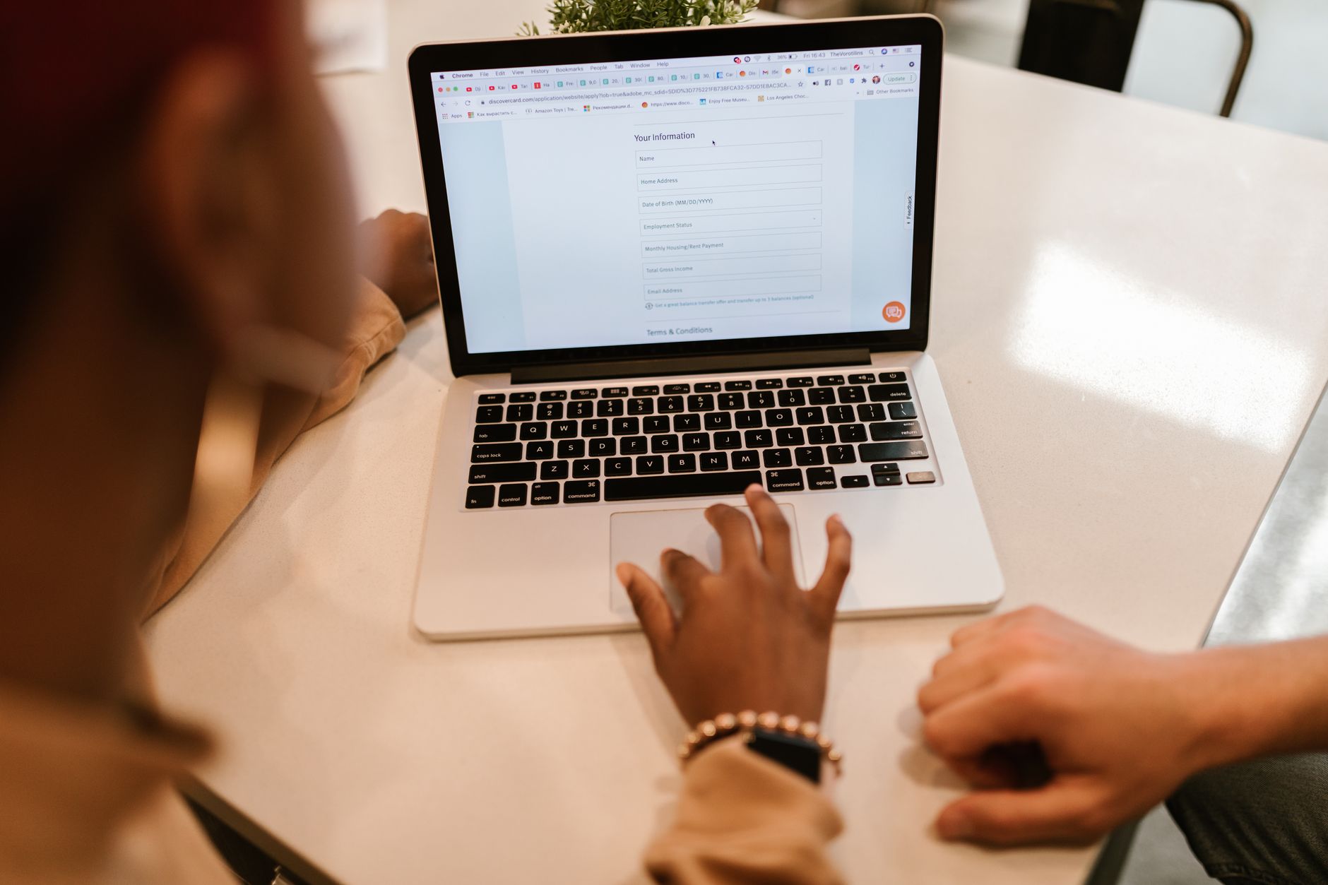 Mani che digitano su un portatile mentre compilano un modulo online