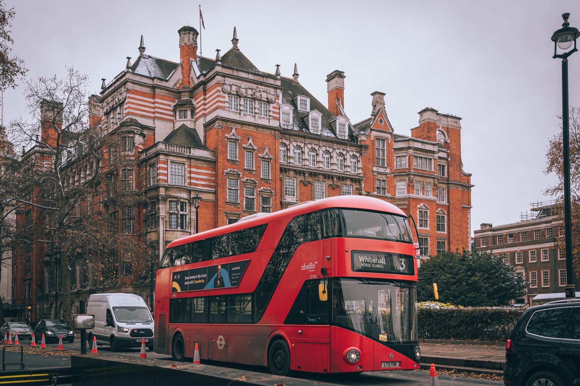 Turisti anziani davanti a un autobus rosso a due piani nel centro di Londra