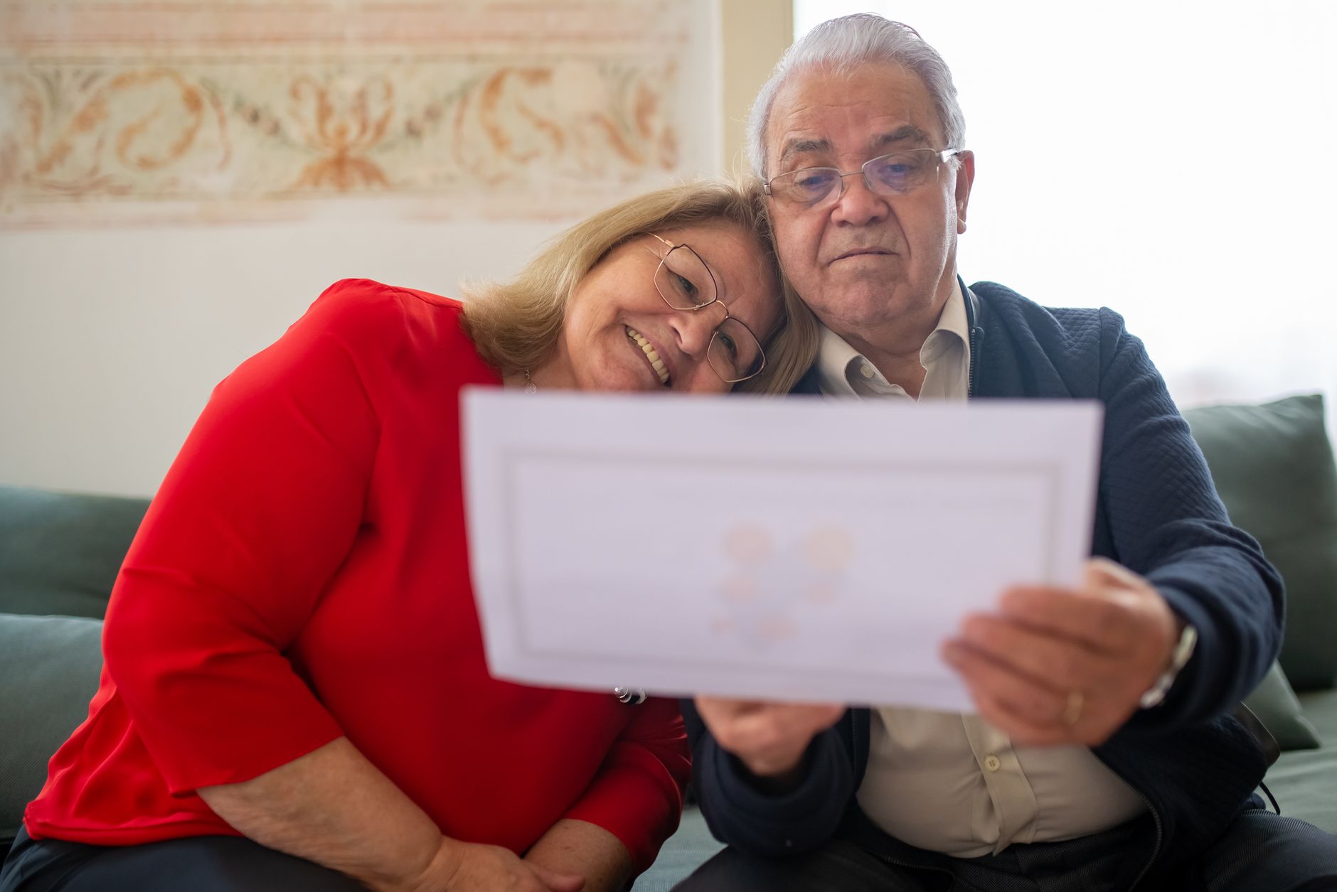 Coppia di pensionati legge i documenti dell'assicurazione sanitaria di viaggio a casa