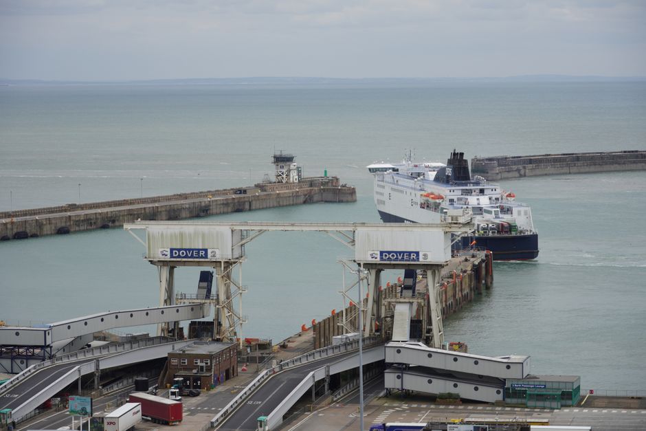 Traghetto passeggeri bianco che si avvicina al porto di Dover con le scogliere sullo sfondo