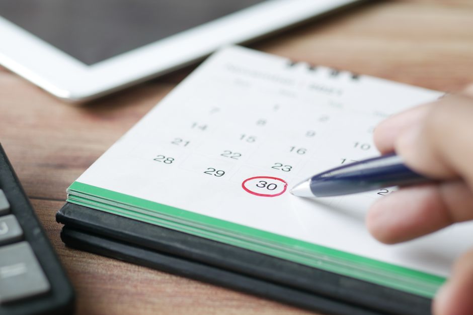 Calendario con data cerchiata accanto a un passaporto per pianificare quando richiedere l'ETA UK